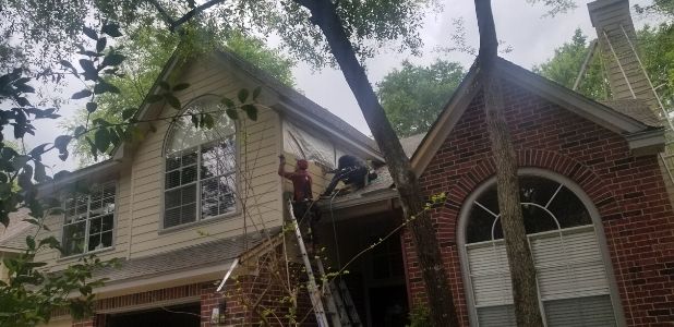 installing new hardie plank siding on a two story house in The Woodlands Texas