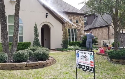 pressure washing front of a stucco house in The Woodlands, Texas