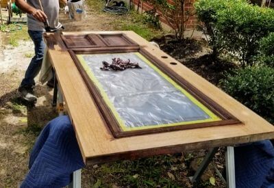 Refinishing and staining front house door in The Woodlands Texas