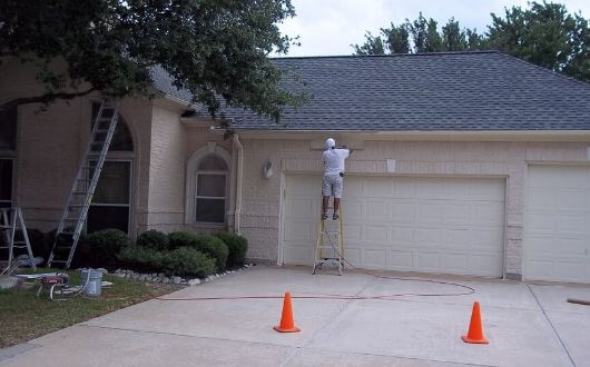 exterior house painting in front of house in The Woodlands Texas