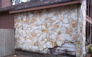flagstone siding with rotted wood siding underneath