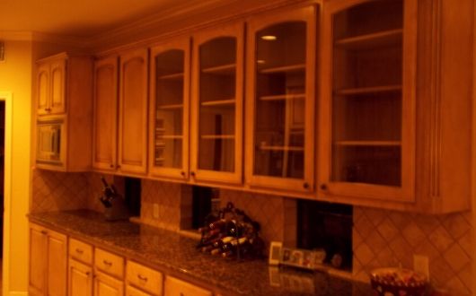 kitchen cabinet refinishing and painting with glass cabinets and wooded look in The Woodlands Texas