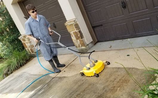 pressure washing the driveway and walkway of house in The Woodlands Texas